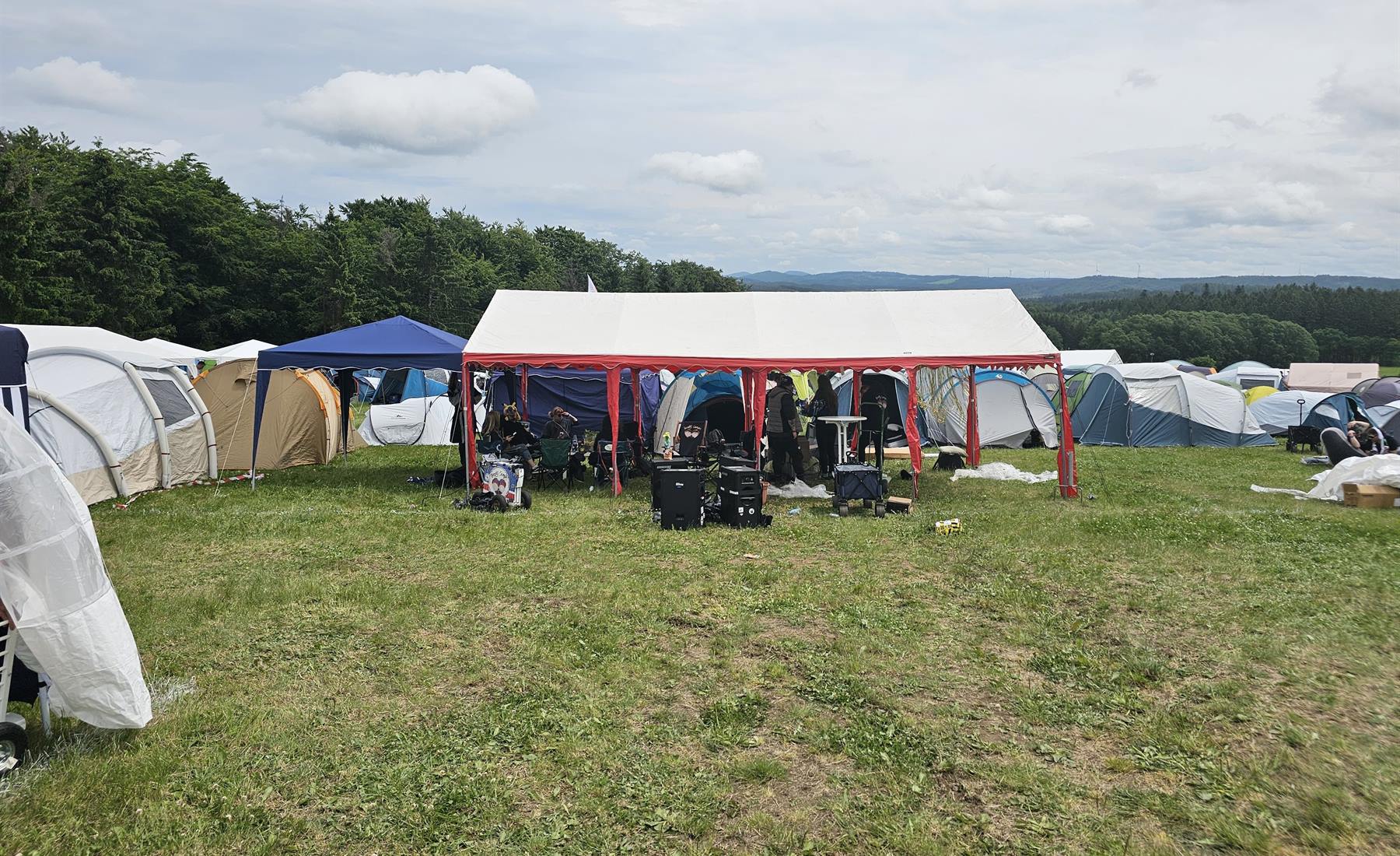 Zeltplatz mit Pavillon und Zeltreihen auf einem Festivalgelände